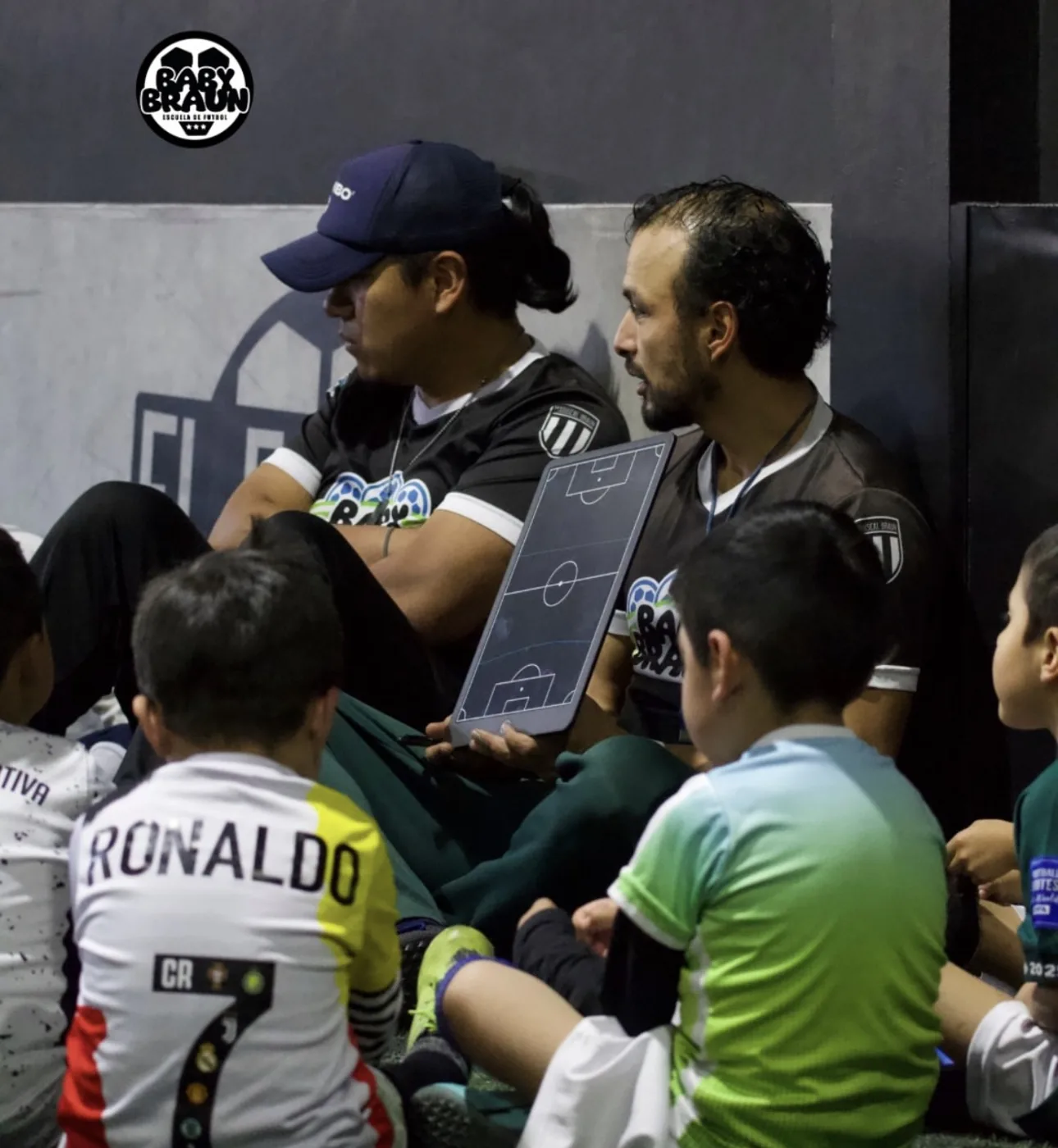 Entrenadores explicando la táctica a los niños en Baby Braun